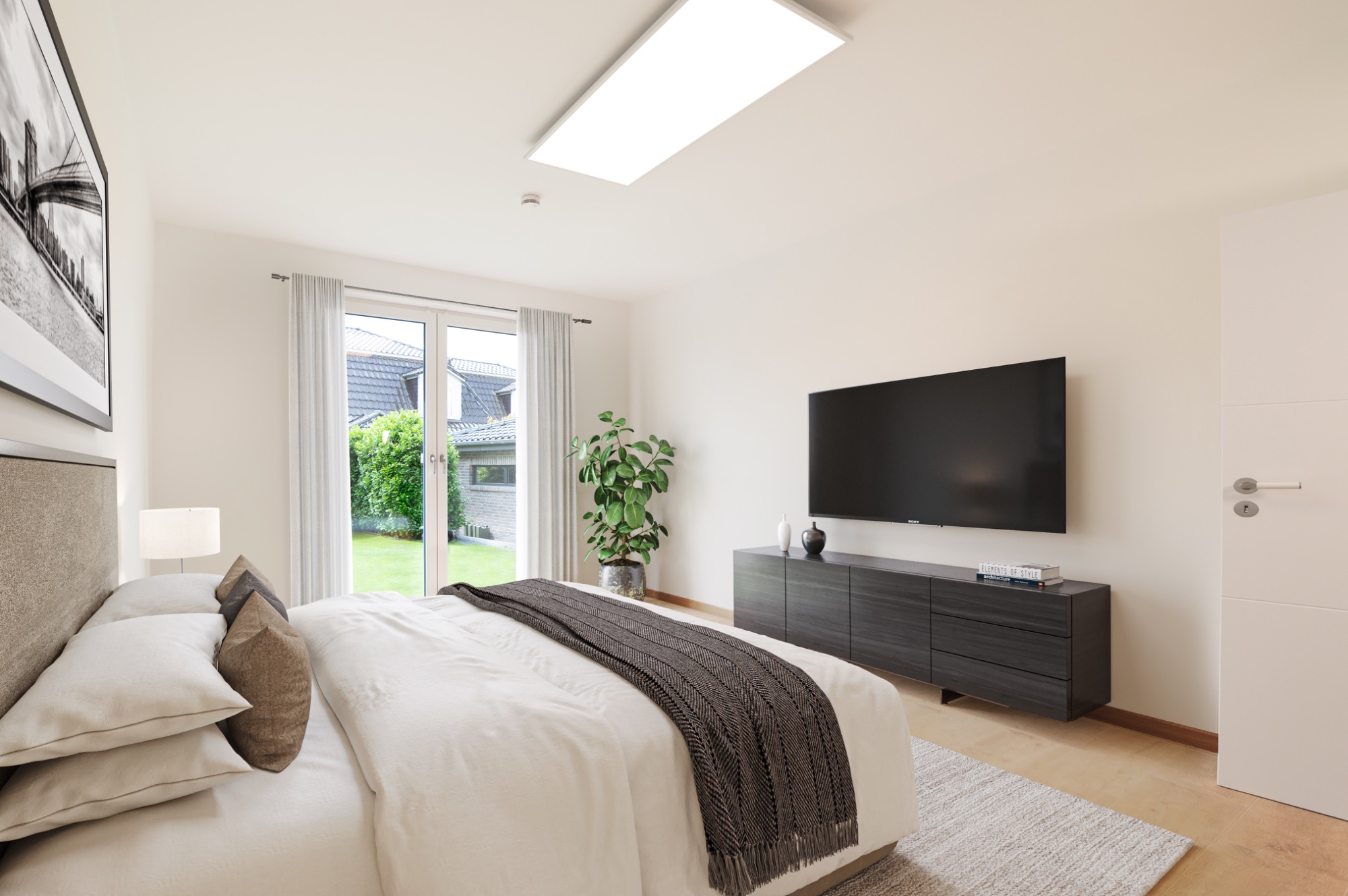 Helles Schlafzimmer mit Doppelbett, Fernseher und Blick auf den Garten.